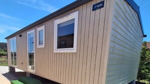 En campingvogn med en navneskilt, vinduer og et grusunderlag.