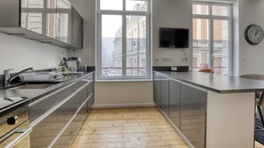 Una cucina moderna con un'ampia finestra, una televisione a schermo piatto e un orologio appeso al muro.