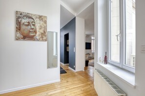 Ein modernes Interieur mit Holzboden, großem Fenster und einer Buddha-Statue an der Wand.