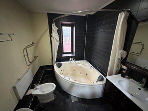 A modern bathroom with a freestanding bathtub, a separate sink, a bidet, and a towel rack. - Gatsby Ortosay (Bishkek)