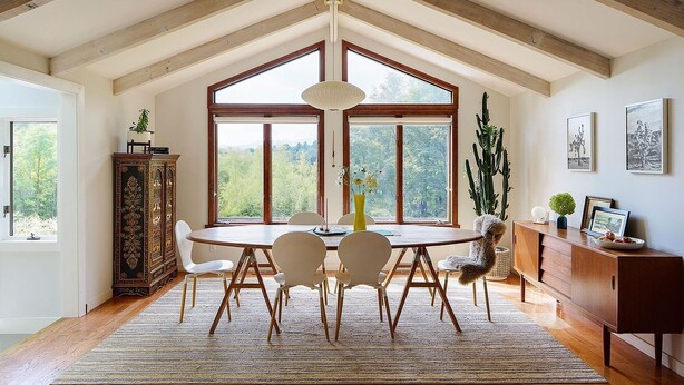 A dining room with a wooden table, white chairs, and a large window. - Serene 4-bedroom family friendly house perfect for your Stowe getaway (Stowe)