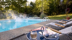 A poolside setting with a table, lounge chairs, and a magazine. - Serene 4-bedroom family friendly house perfect for your Stowe getaway (Stowe)