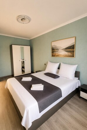A hotel room with a bed, a wardrobe, a painting, and a ceiling light. - Luxury Unique Retreat in Armenia (Vanadzor)