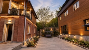 A courtyard with two-story buildings, a bench, and a tree. - Luxury Unique Retreat in Armenia (Vanadzor)