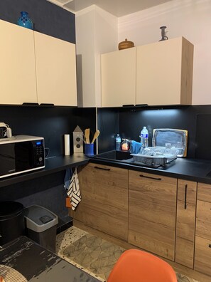 Una cocina compacta con microondas, fregadero y armarios de madera.