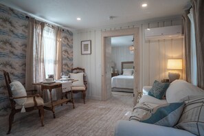 Une pièce comprenant un lit, un canapé, une table à manger avec des chaises et une petite table avec une lampe.