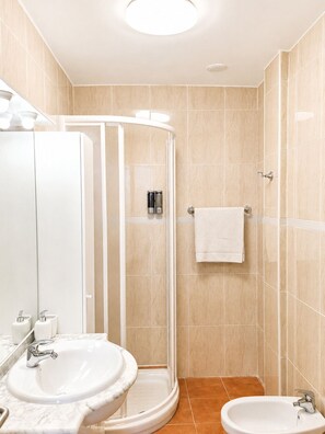 Een douche, een bidet, handdoeken, zeep