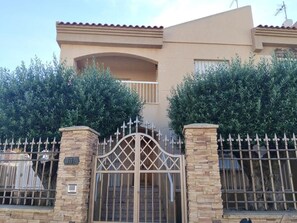 A two-story building with a gated entrance, stone pillars, and a balcony. - VACATION HOME FOR SEASONAL RENTAL (Calabardina)
