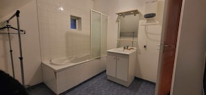 Une salle de bain avec une baignoire, un lavabo, un miroir et une douche.