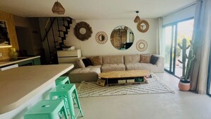 Een moderne woonkamer met een bank, salontafel en een trap.