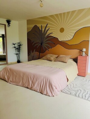 Un dormitorio con cama, mesita de noche, cómoda y un mural en la pared.