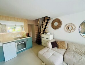 A modern kitchen with a dishwasher, oven, and a dining area with a sofa and a mirror. - Provence house with swimming pool (Lambesc)