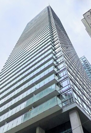 Un immeuble de grande hauteur doté d’une façade moderne en verre et d’une disposition de fenêtres en forme de quadrillage.
