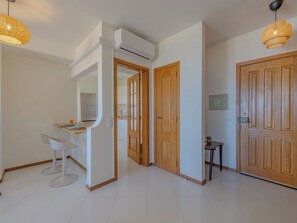Ein modernes Interieur mit Küchenzeile, einem Esstisch mit Stühlen und Holztüren.