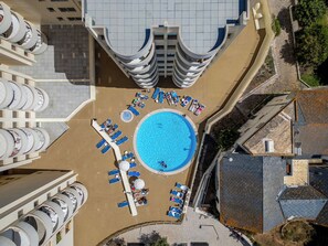 An aerial view of a hotel with a central swimming pool surrounded by sun loungers and a circular arrangement of balconies. - Algarvemor - Casa Do Tio by Interhome (Portimão)