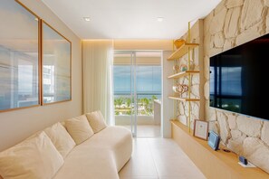 Ein modernes Wohnzimmer mit einer Couch, einem Fernseher und einem Balkon mit Blick.