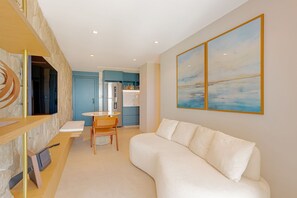 Ein modernes Interieur mit einer Couch, einem Esstisch und einer Küchenzeile.