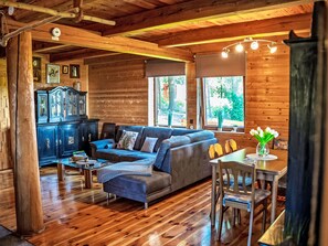 A wooden interior with a sofa, dining table, and chairs. - Chata Ujo by Interhome (Hranice)