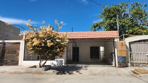 A residential building with a tiled roof, a gated entrance, and a tree in front. - Newly Remodeled Loft - Fast WiFi - A/C - 9 Min drive to Malecon (La Paz)