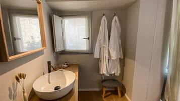 Een douche, een bidet, handdoeken, toiletpapier