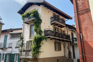 Ein mehrstöckiges Gebäude mit Balkonen, einer sichtbaren Treppe und einer Ziegelwand.