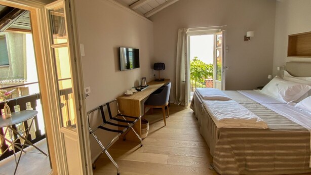 A bedroom with a bed, a desk, a chair, a TV, and a balcony. - La Torre Belgirate - Luxury Rooms - Glicine - By Guestaly (Belgirate)