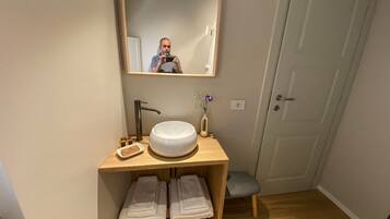 Een douche, een bidet, handdoeken, toiletpapier