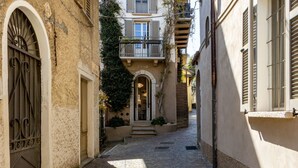 A narrow cobblestone alleyway between buildings with arched doorways and a small staircase leading to a door. - La Torre Belgirate - Luxury Rooms - Glicine - By Guestaly (Belgirate)