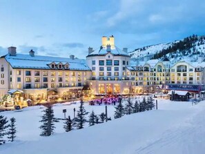 Ett stort hotell med flera byggnader, en skidbacke och snötäckta träd.