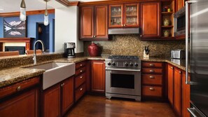 A kitchen with wooden cabinets, a stainless steel stove, a microwave, and granite countertops. - 2-bedroom residence in luxury resort with spa & nightly turn down service (Avon)