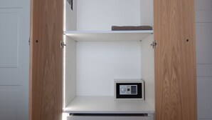 Ein Zimmer mit einer weißen Tür, einem Holzschrank und einem kleinen Safe in der unteren Schublade.