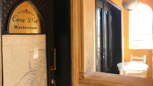 Placa indicando 'Casa D'or Masterroom', com uma porta e janela, e uma cadeira no interior.