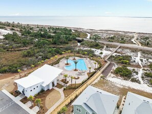 Ein Resort mit Schwimmbad, einem weißen Gebäude und Blick auf den Ozean.