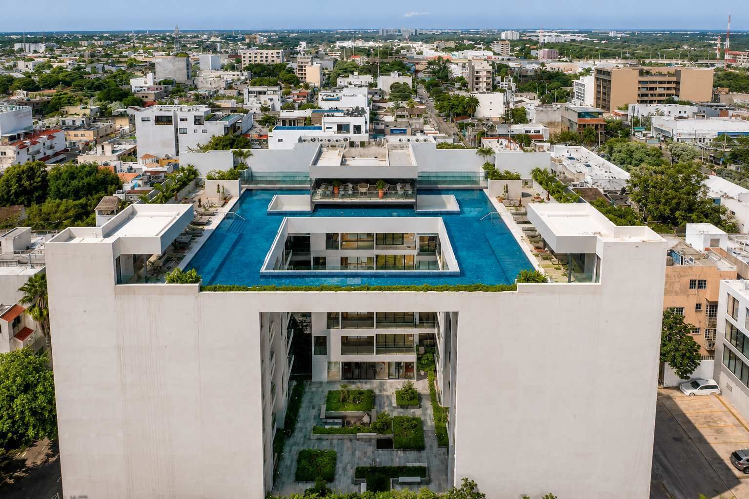 A high-rise building with a rooftop pool, a central courtyard, and a view of the surrounding cityscape.