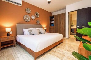 Ein Schlafzimmer mit Bett, Nachttischen, Wanddekoration und einem Kleiderschrank.