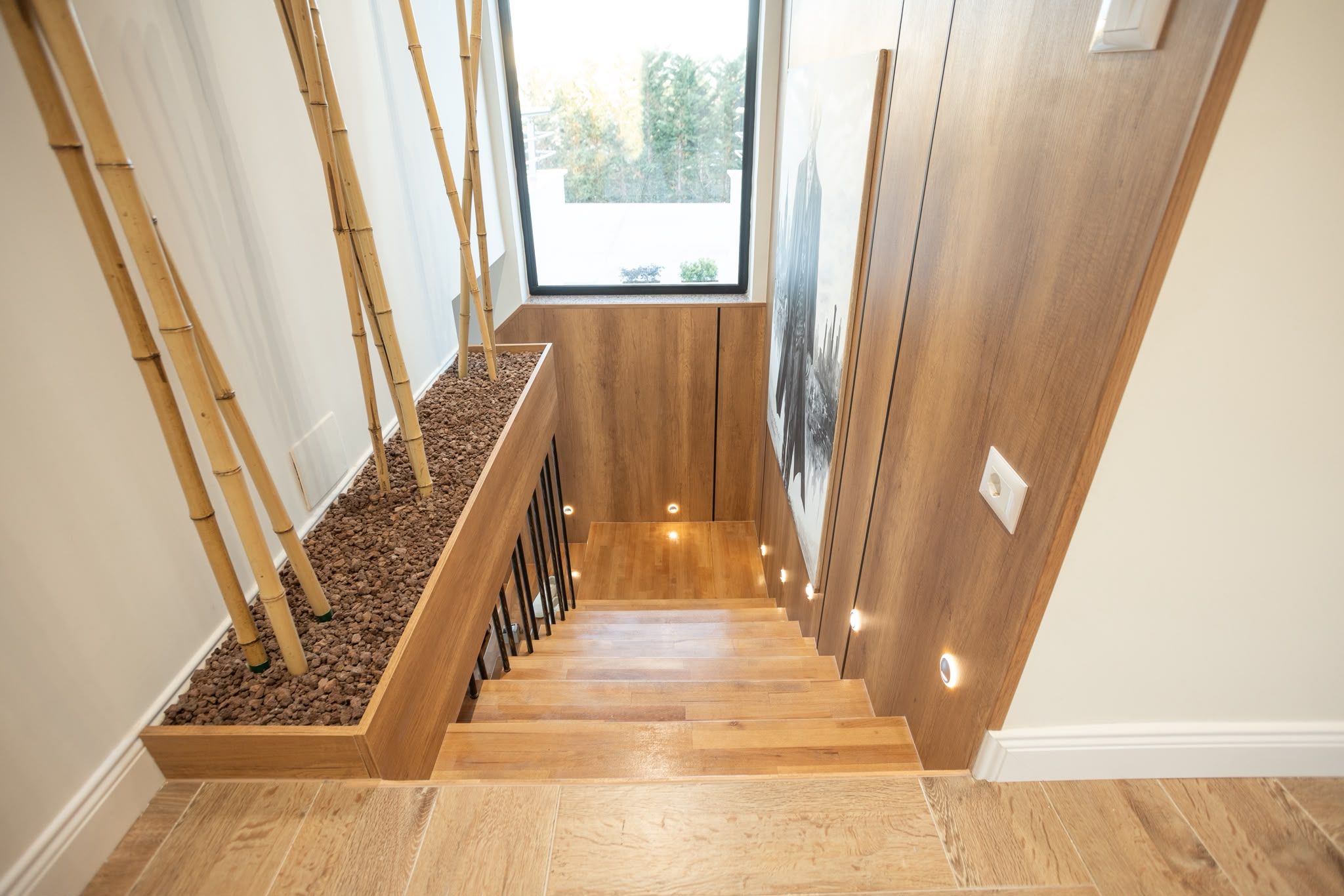 A wooden staircase with a planter on the left and a door on the right.