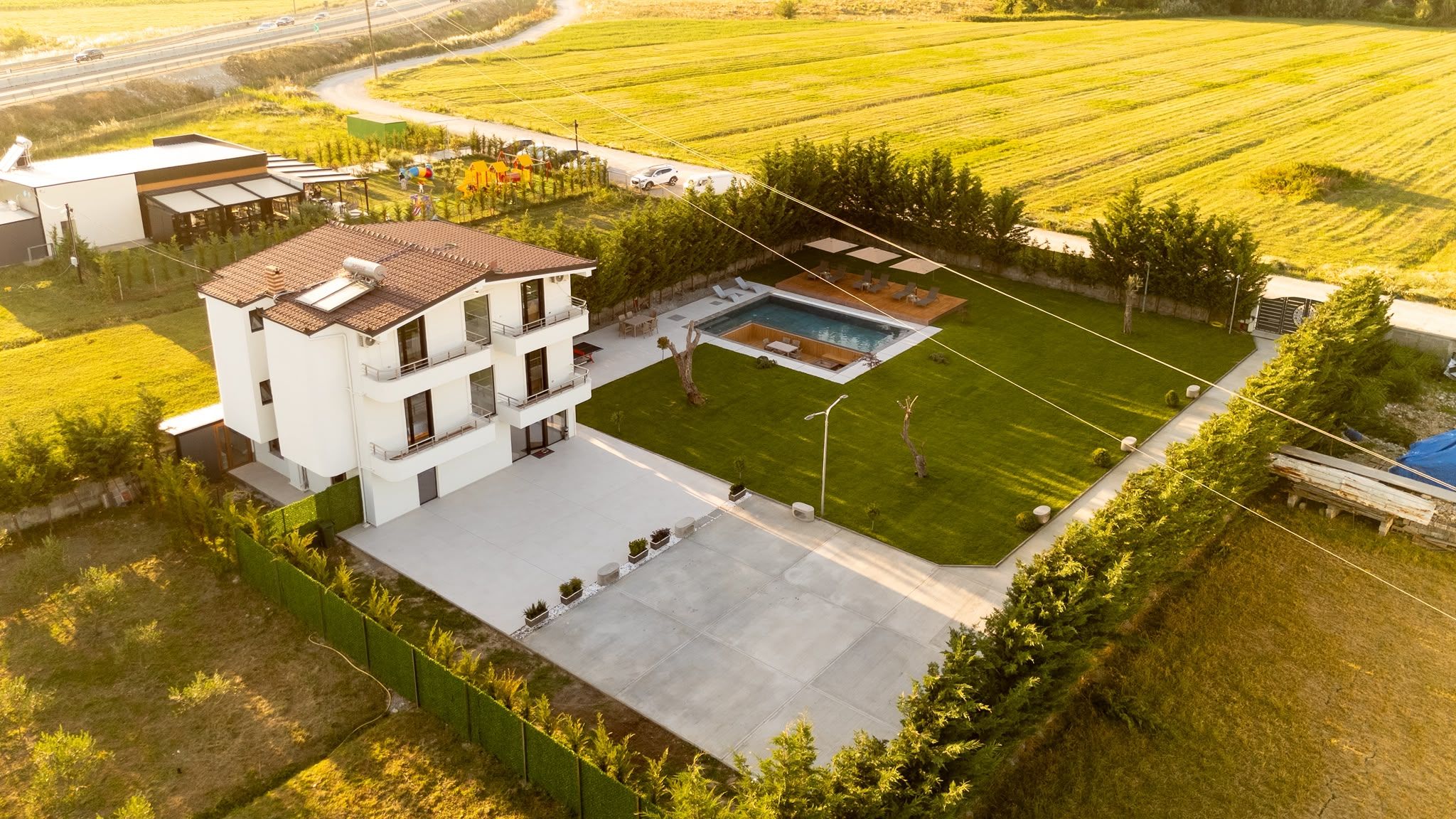 Un edificio moderno de varios pisos con piscina y un césped bien cuidado.