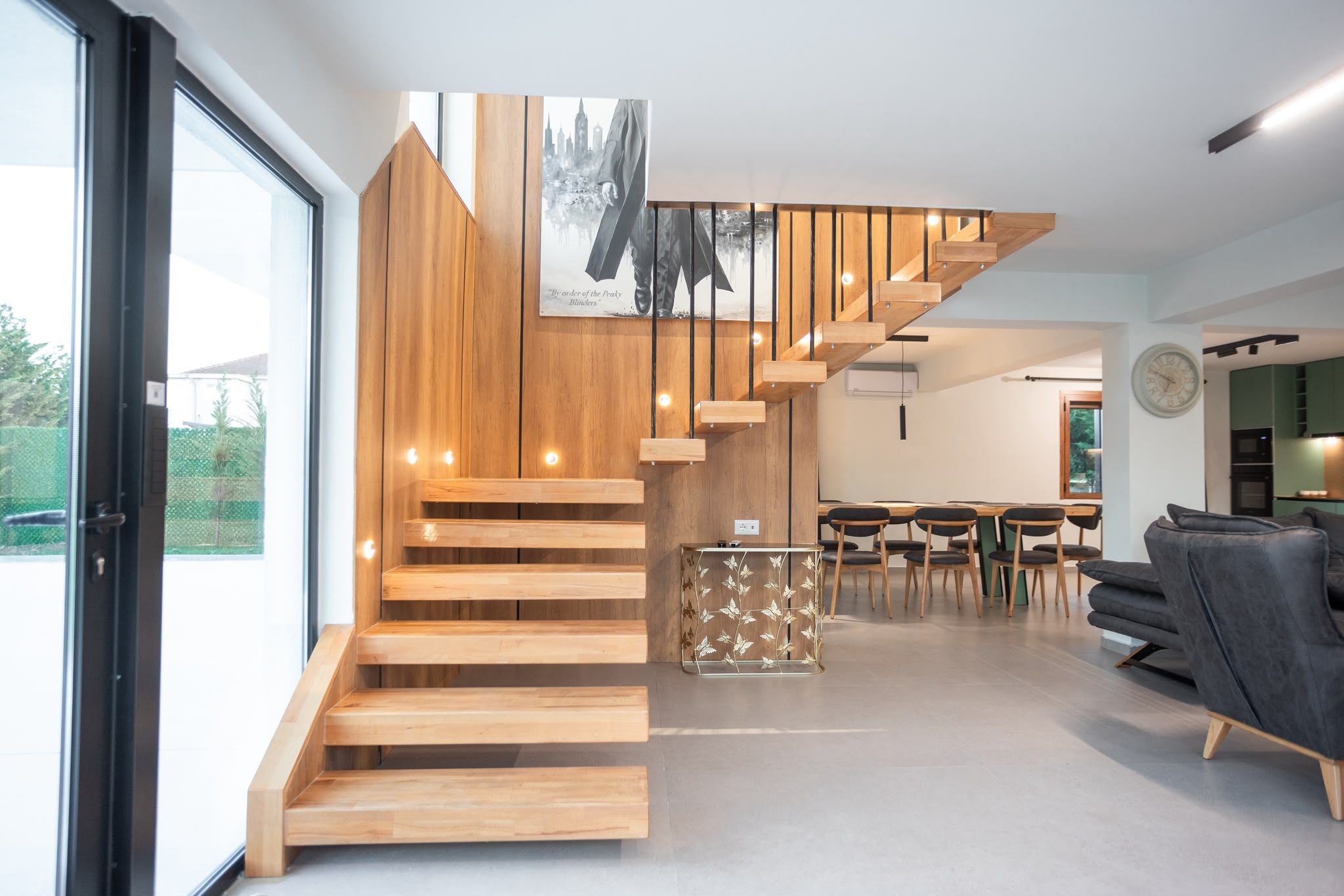 Ein modernes Interieur mit einer Holztreppe, einem Essbereich und einem Wohnraum.