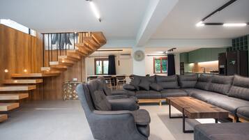 A modern living room with a sectional sofa, a coffee table, and a staircase with wooden steps.