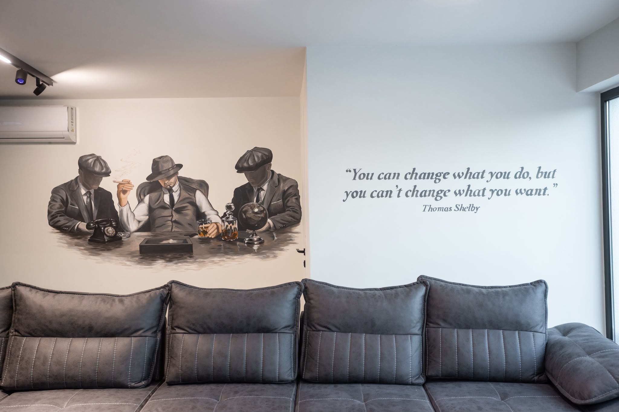 A wall with a quote by Thomas Shelby and a painting of three men at a table.