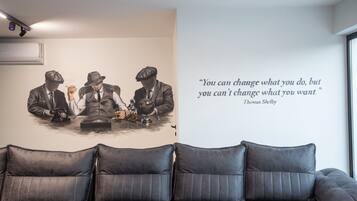A wall with a quote by Thomas Shelby and a painting of three men at a table.