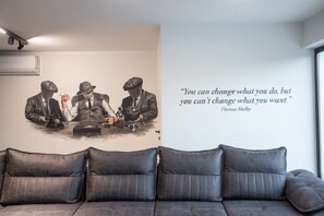 Una pared con una cita de Thomas Shelby y un cuadro de tres hombres sentados a una mesa.
