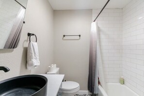 Een haardroger, handdoeken, zeep, toiletpapier