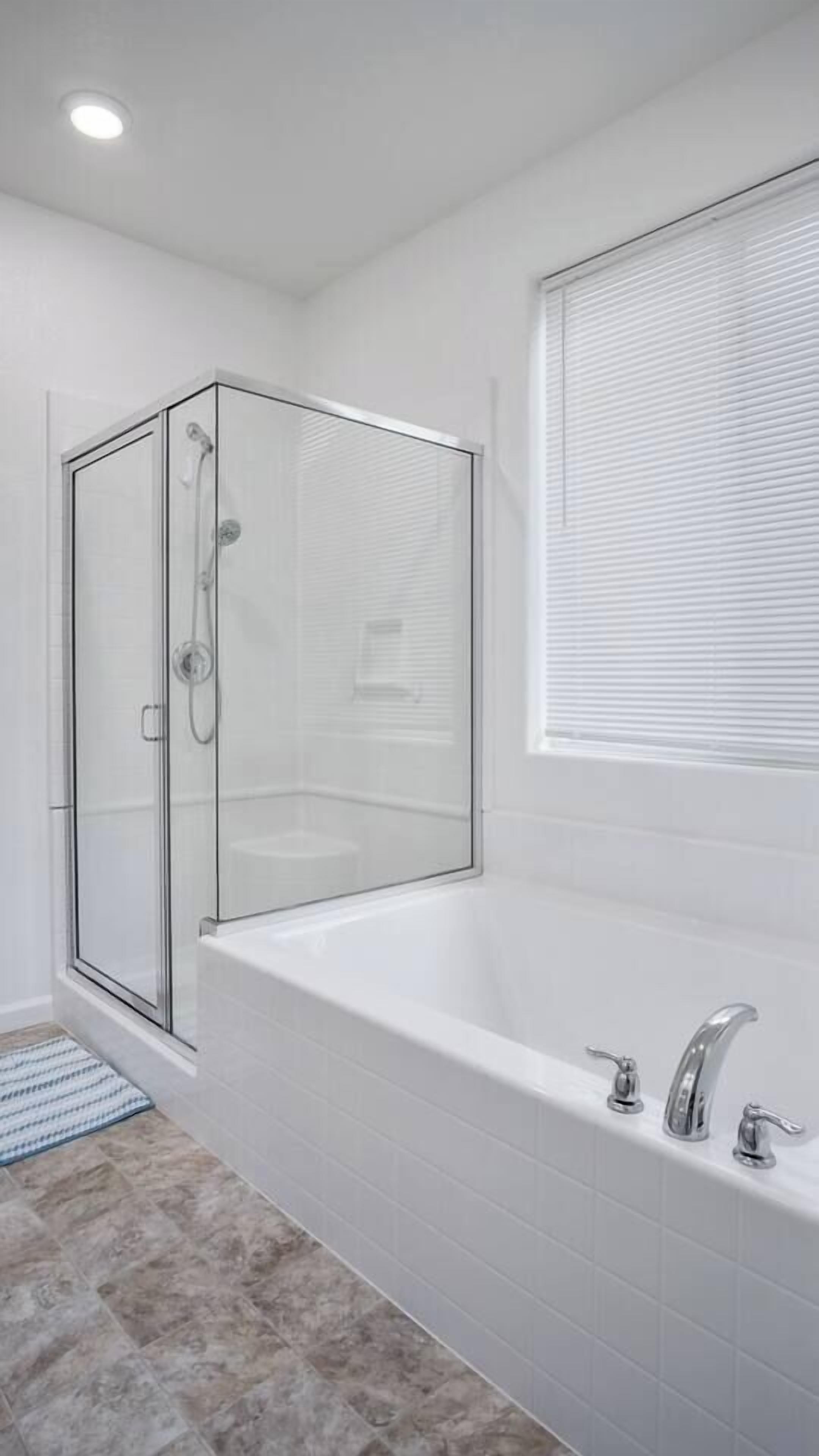 Ein modernes Badezimmer mit einer Glasdusche, einer freistehenden Badewanne und einem Fenster mit Jalousien.