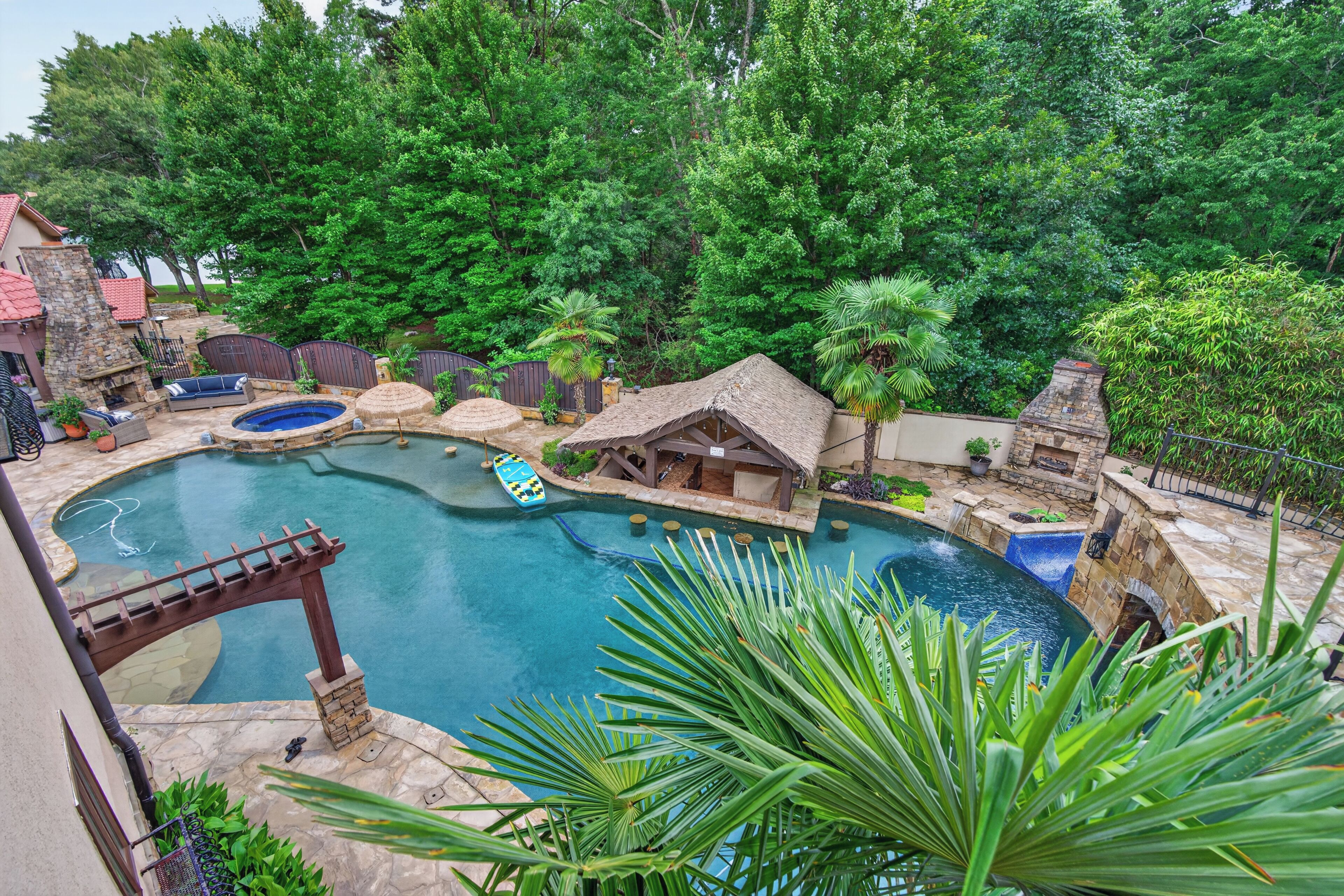 Un patio trasero con piscina, jacuzzi y una pequeña casa.