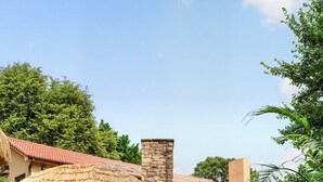 Un edificio con chimenea de piedra, techo de paja y pared de piedra.