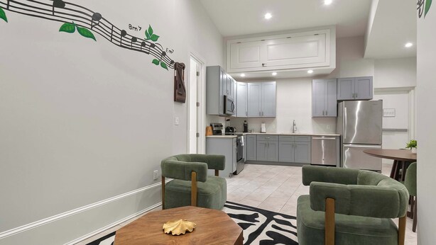A modern kitchen with grey cabinets, a stainless steel refrigerator, and a microwave.