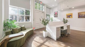 A modern reception area with a reception desk, seating area, and large windows.