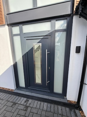 A modern exterior with a dark-colored door, a glass panel, and a metal handle. - Carbis Bay Retreat (Carbis Bay)