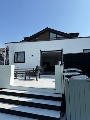 A modern two-story house with a patio, a dining area, and a garage. - Carbis Bay Retreat (Carbis Bay)
